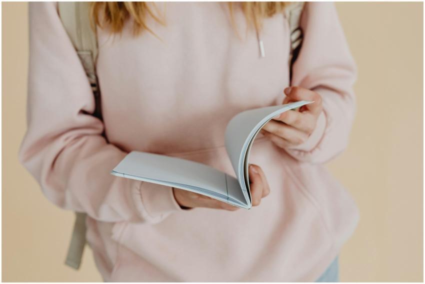 Close-up of a teenager holding a notebook, symboli
