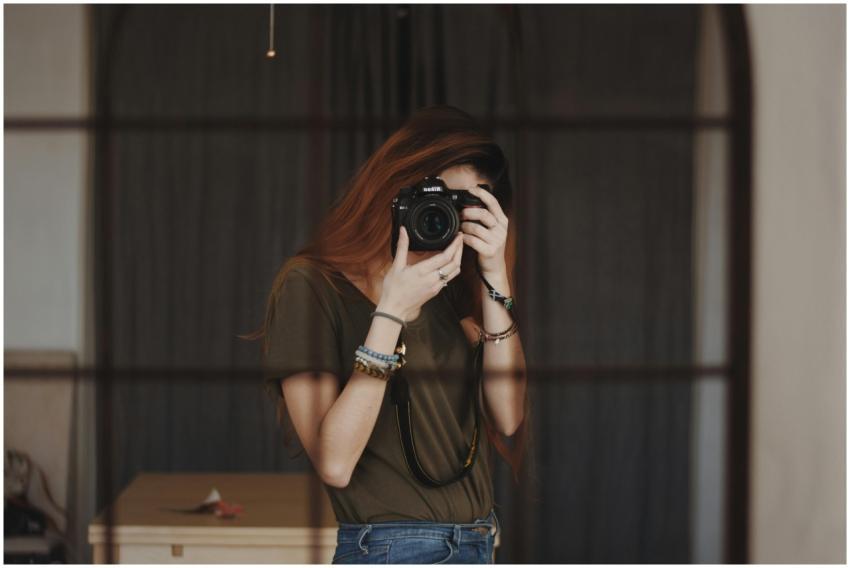 A female photographer capturing a self-portrait wi