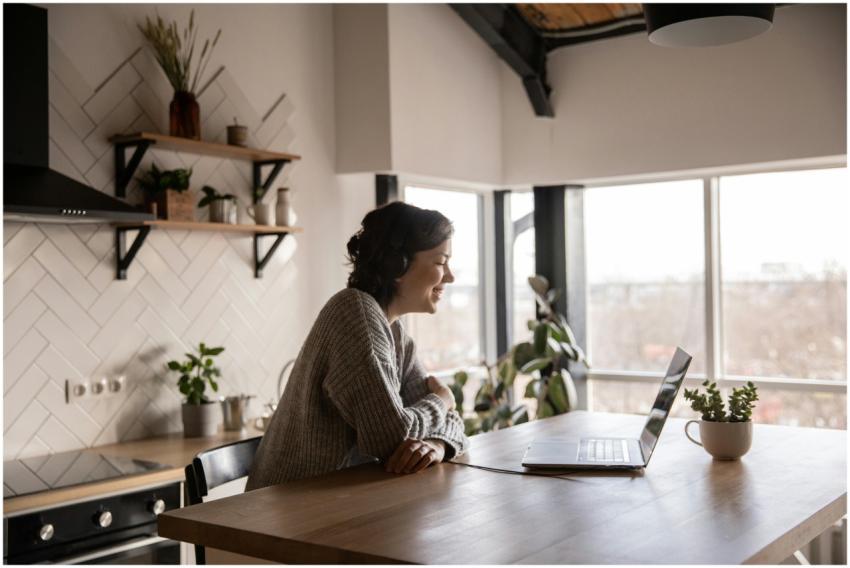 A woman enjoys a video call on her laptop in a mod
