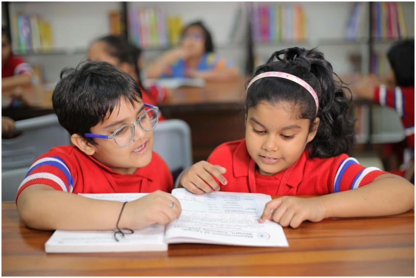 Two young children reading together in a bright cl