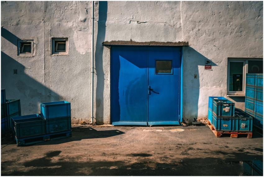 An industrial blue door surrounded by blue storage