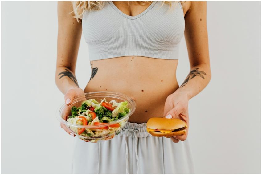 A woman in a sports bra holding a salad and cheese