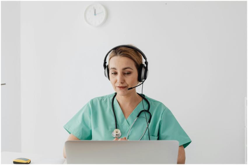 A female doctor in scrubs using a laptop for a vir