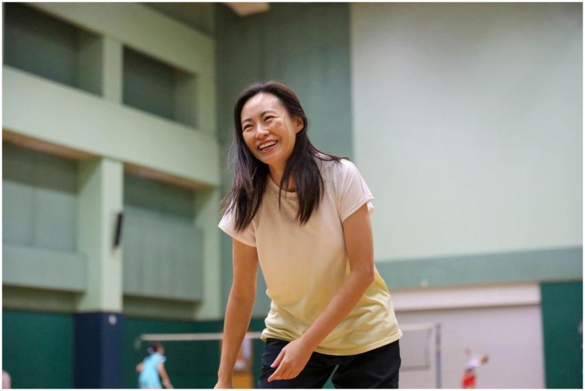 Smiling woman enjoying a game of badminton in an i