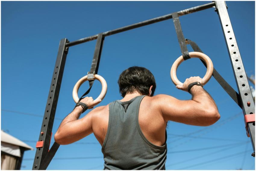 Athletic man doing a pull-up exercise on gymnastic