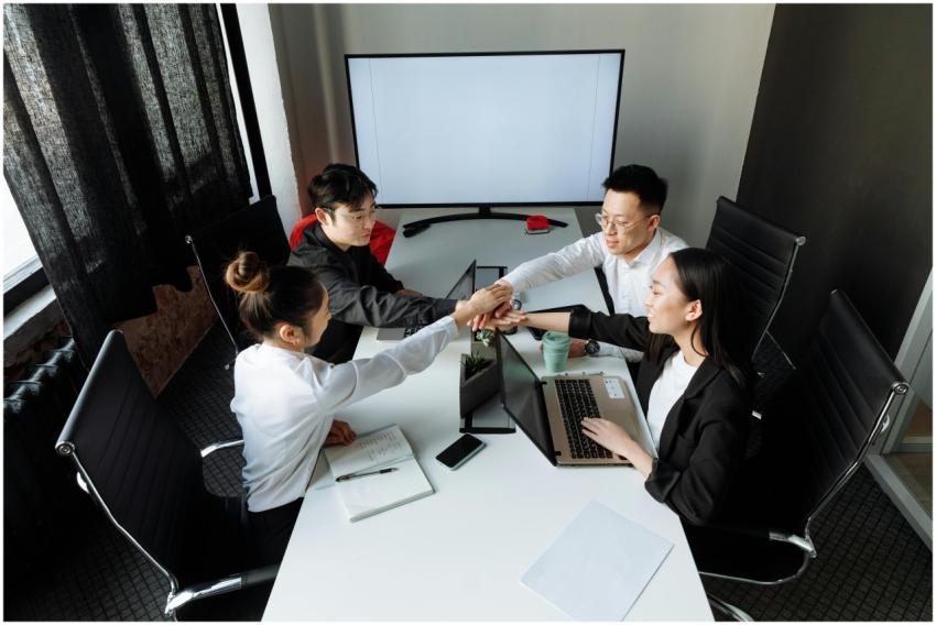 Asian business team collaborating and shaking hand