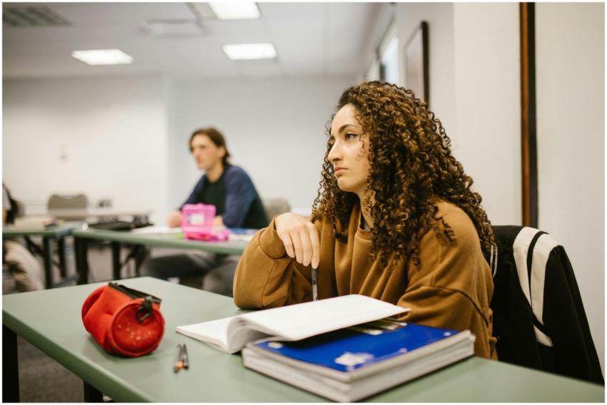 Young woman in classroom, focused on study materia
