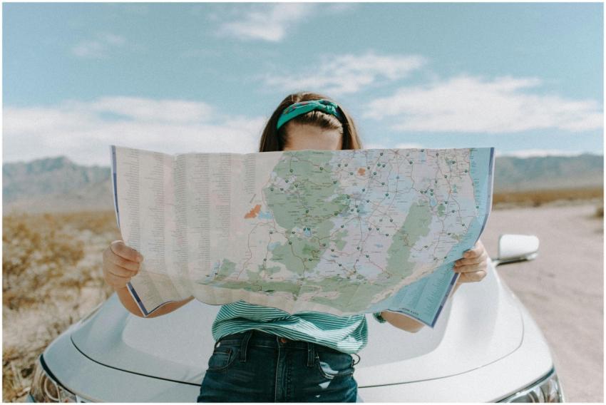 A woman holds a map while traveling through the sc