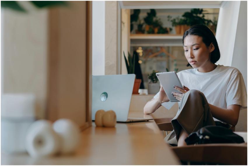 Asian woman using a tablet for remote work in a mo