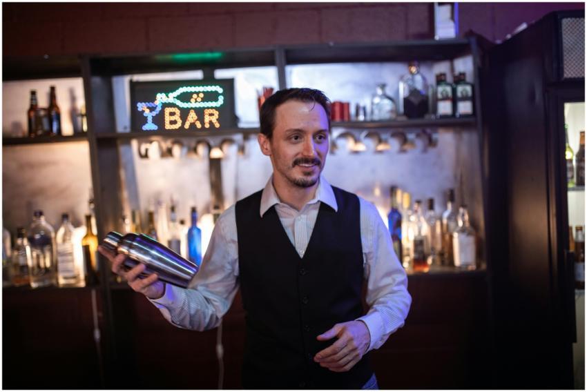 A bartender skillfully mixing drinks in a vibrant