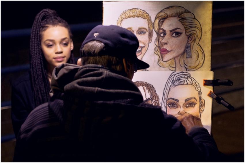 A street artist sketches a portrait of a woman dur