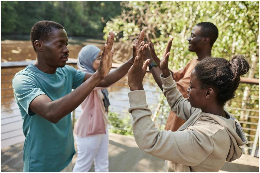 A group of friends enjoying a high-five outdoors,