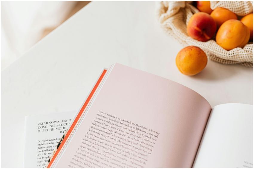 From above of opened book placed on white table ne