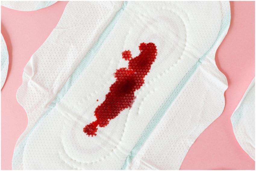 A sanitary pad with a visible blood stain on a pin