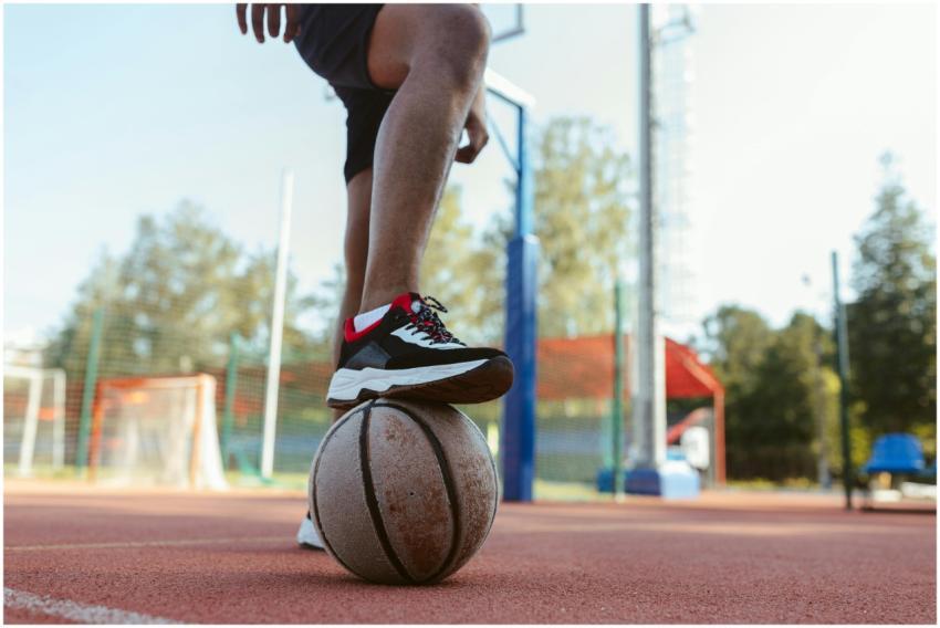 A person standing on an outdoor basketball court w