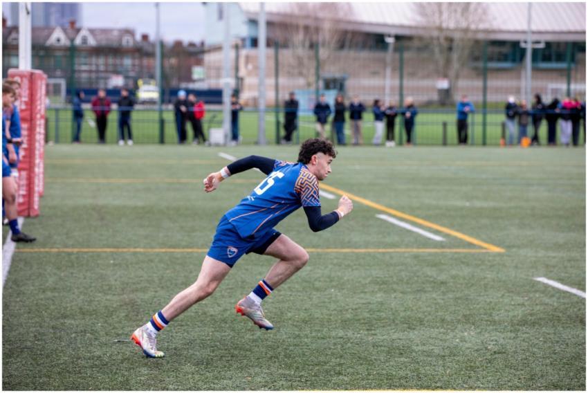 Rugby player in action sprinting on a field in Man