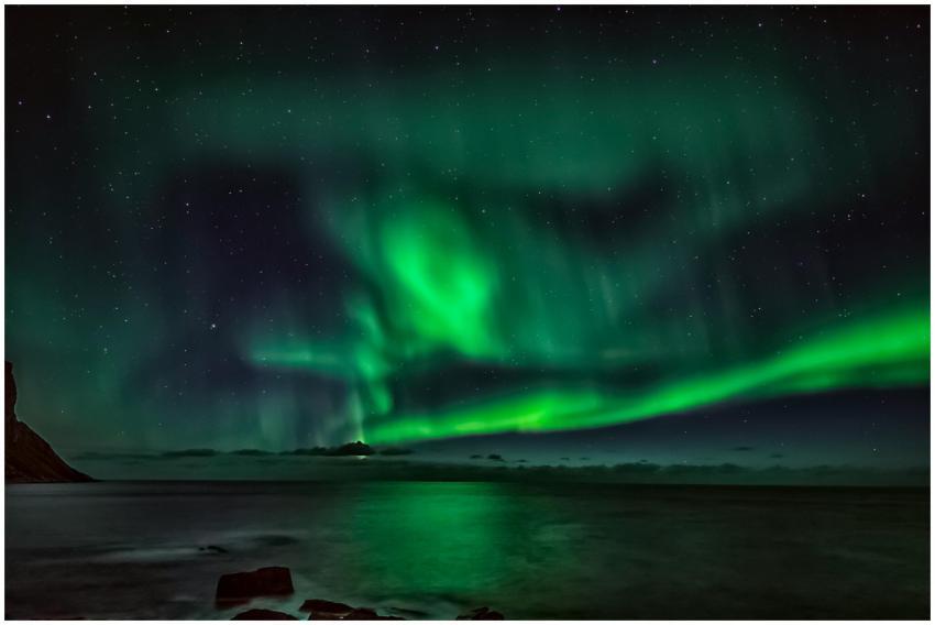 Starry night sky with green polar lights over wavi