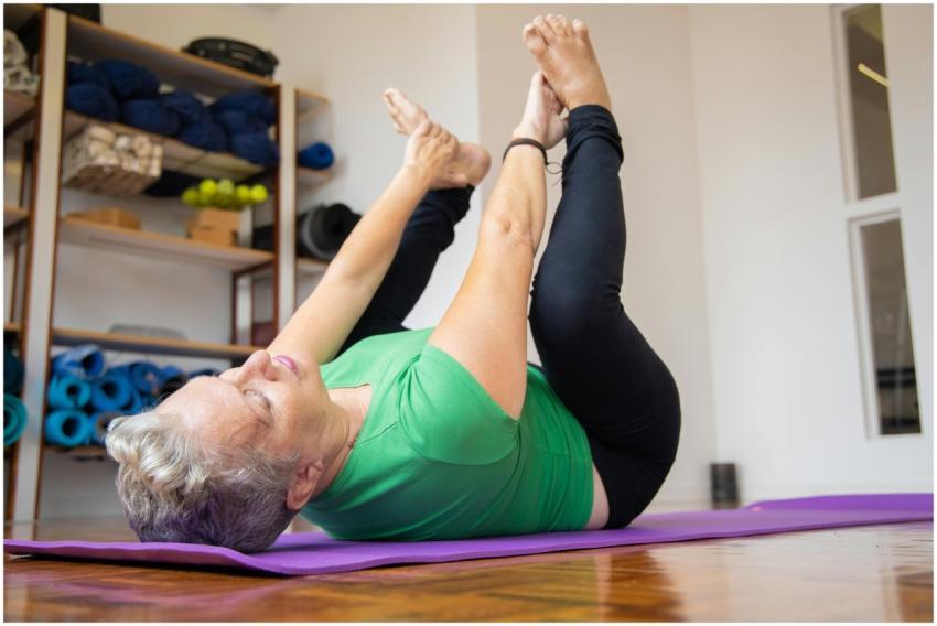 Elderly woman performing yoga exercise on mat, pro