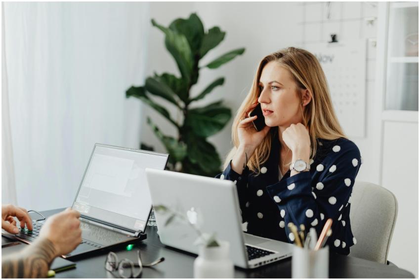 Businesswoman multitasking with phone and laptop i