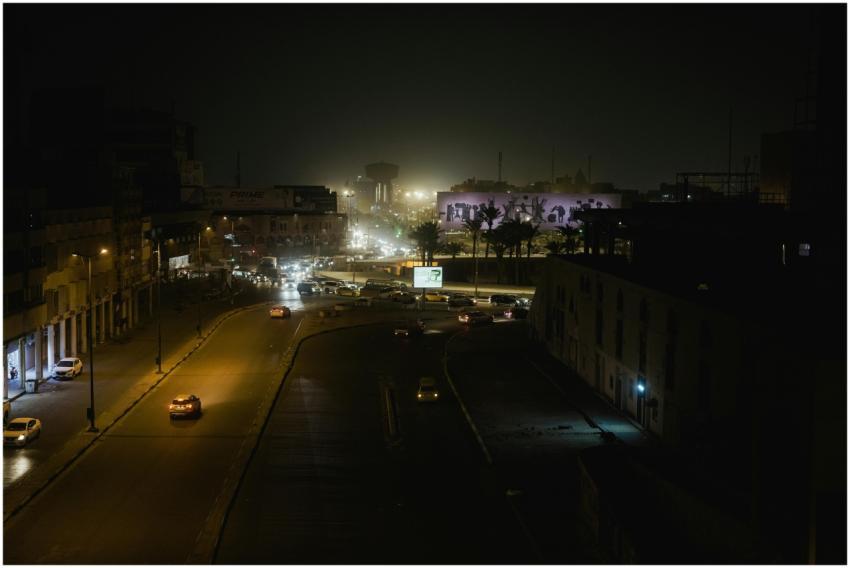 Aerial view of a city street at night with glowing