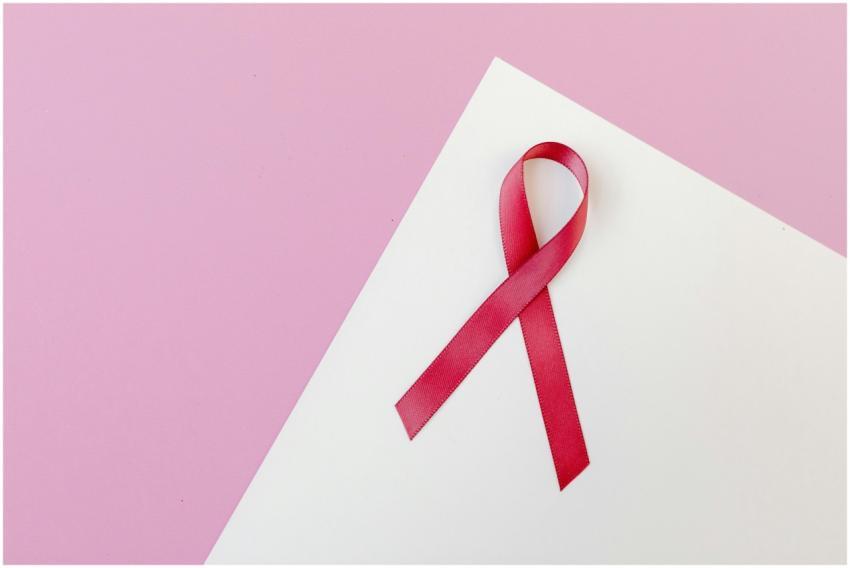 Close-up of a pink awareness ribbon on a white pap