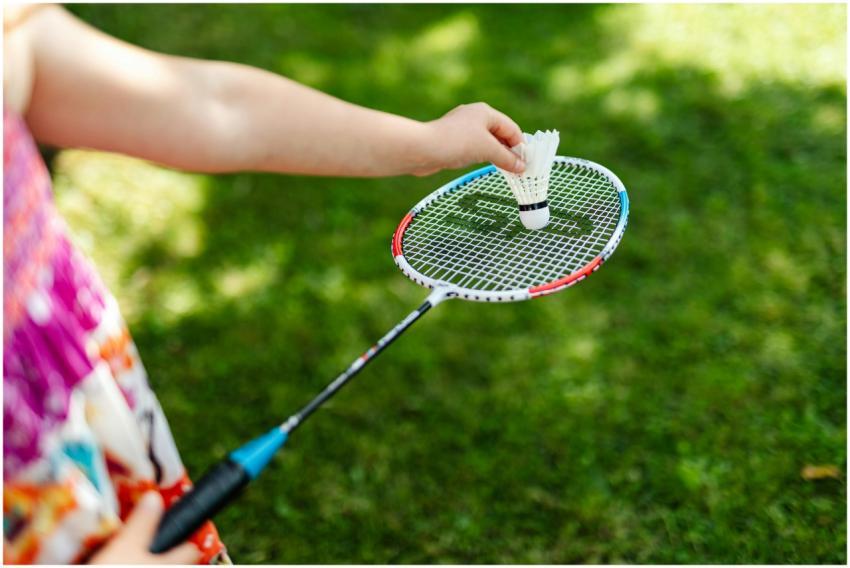 A detailed close-up of a person holding a badminto