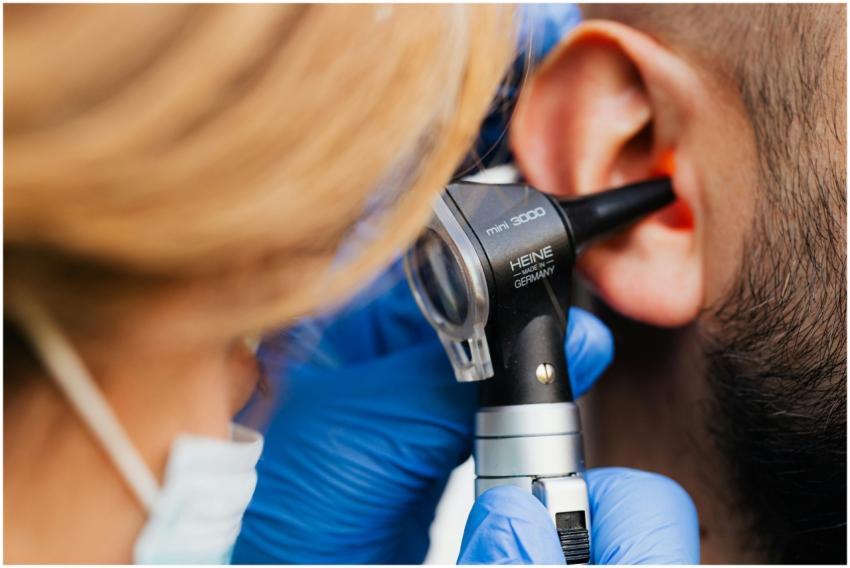 A medical professional examines a patient's ear us