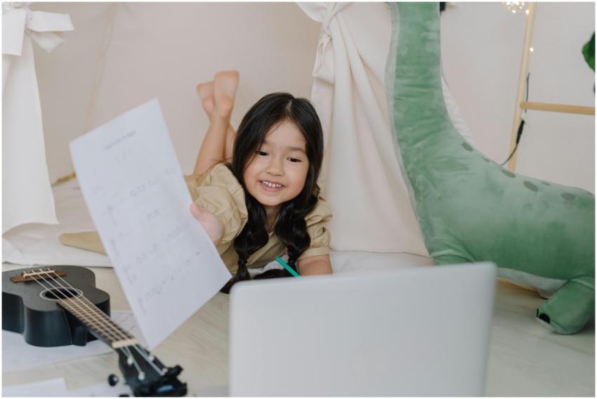 Happy child learning ukulele online at home with s