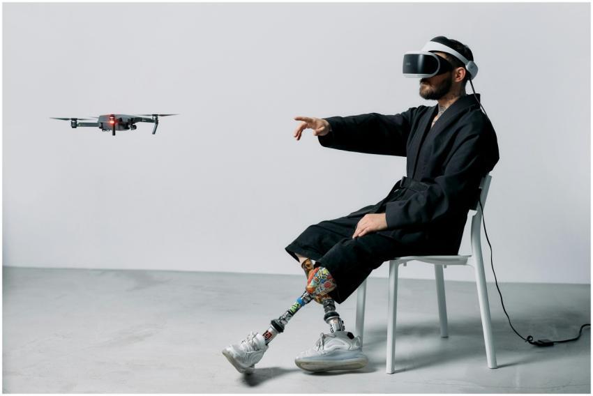 Man with prosthetics using VR headset and drone in