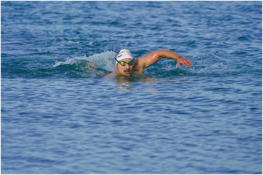 Athlete swimming freestyle in the clear waters of