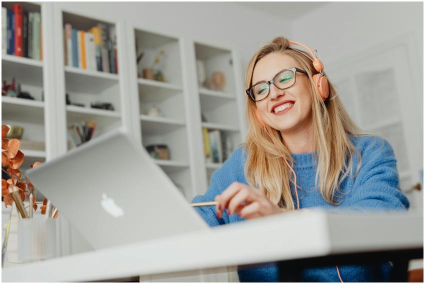 Smiling woman wearing eyeglasses and headphones, w