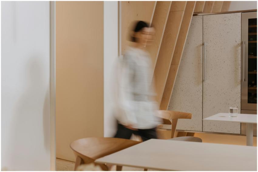 Minimalist interior captures a blurred figure walk