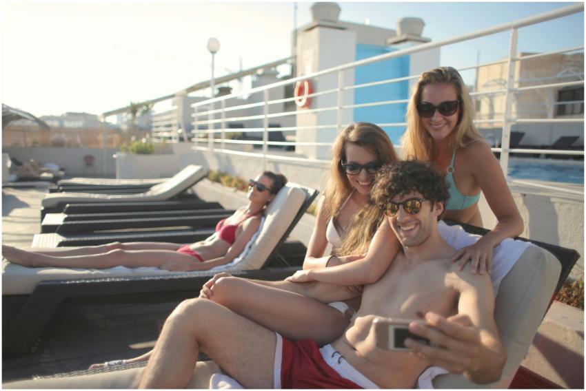 Smiling young people in sunglasses and swimsuits s