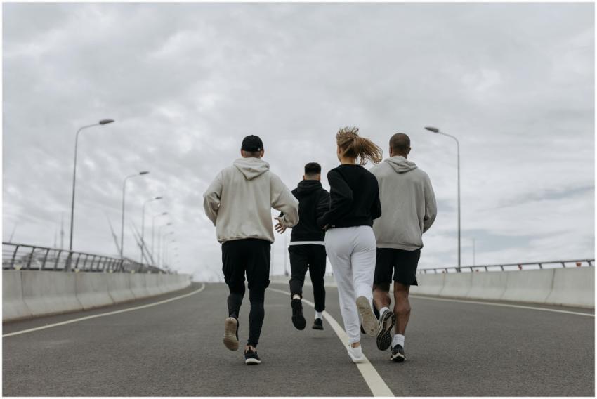 Four adults in athletic wear jogging together on a