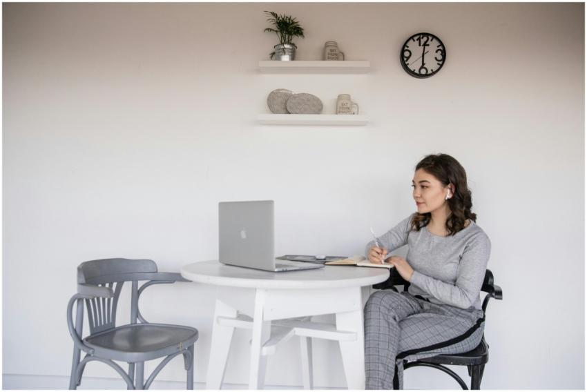 A young woman sitting at a desk with a laptop and