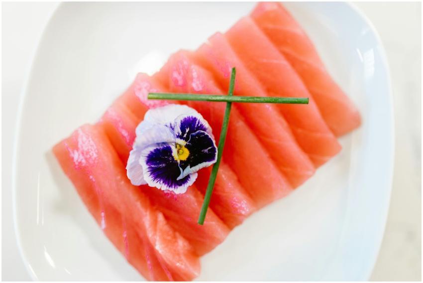 Delicate salmon sashimi topped with an edible flow
