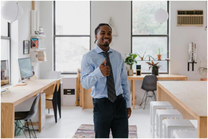 Smiling man in formalwear showing thumbs up gestur