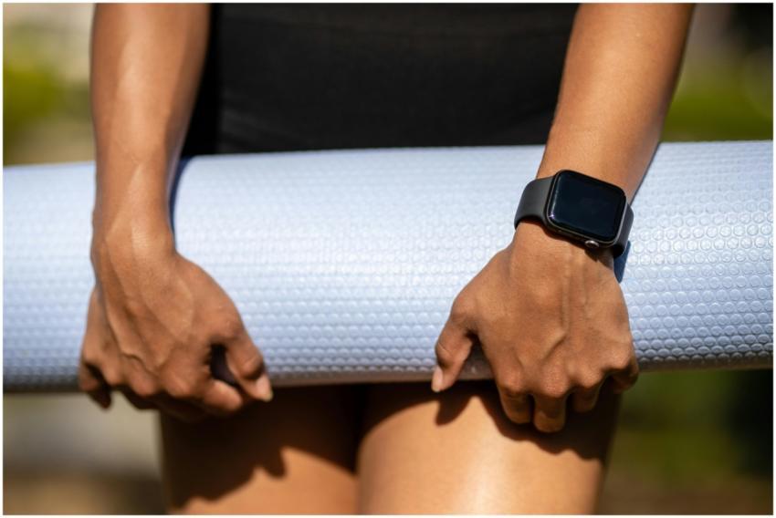 Close-up of hands holding a yoga mat, wearing a sm