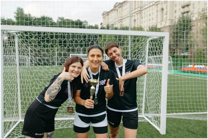 Three female soccer players celebrate their win wi