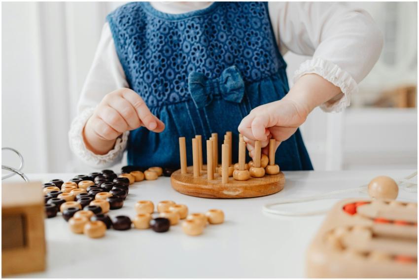 A child interacts with a wooden sorting toy, devel