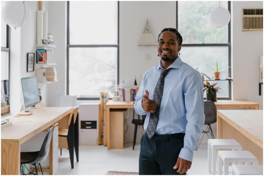 Smiling businessman in a modern office giving a th