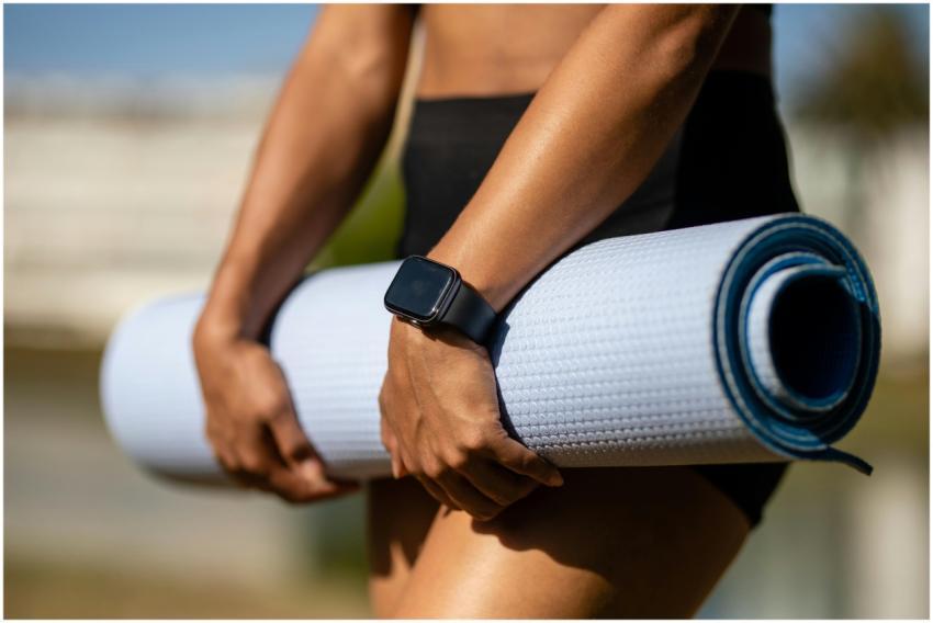 Close-up of a person holding a yoga mat outdoors w