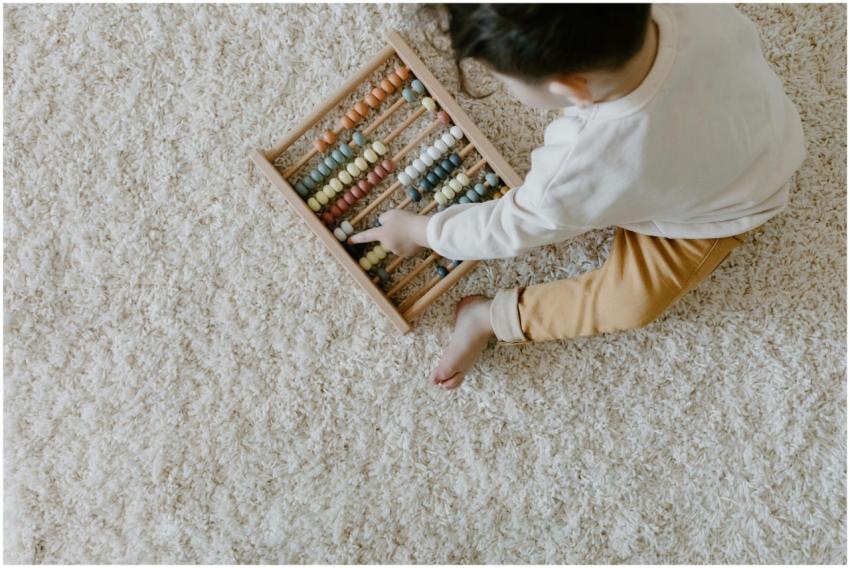 Young child playing with a colorful wooden abacus