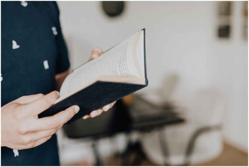 Close-up of hands holding an open book, focused on