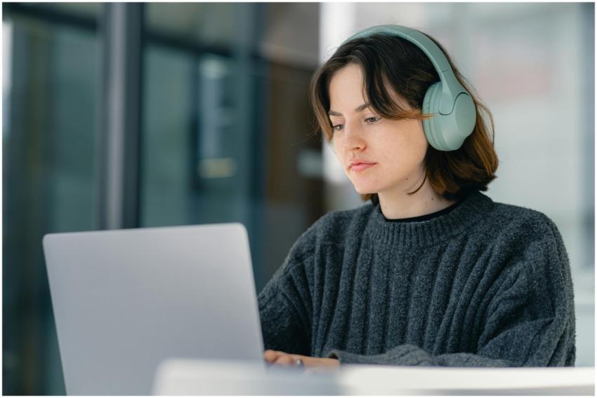 Young woman wearing headphones working on a laptop