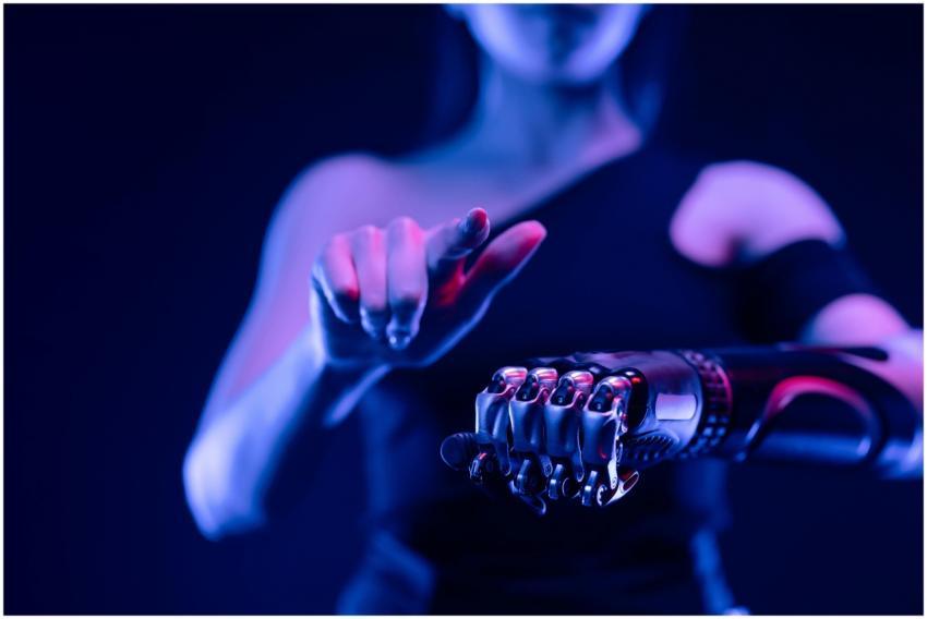 Close-up of a robotic hand with a woman pointing,