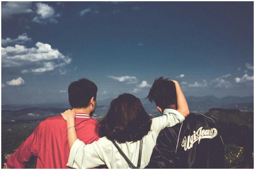 A group of three friends embracing and enjoying th