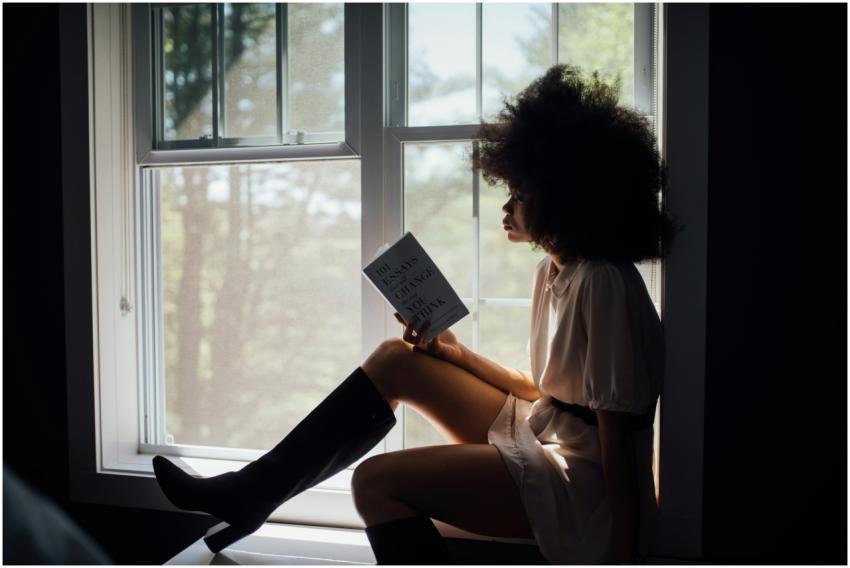 A woman enjoys a peaceful reading session by a win