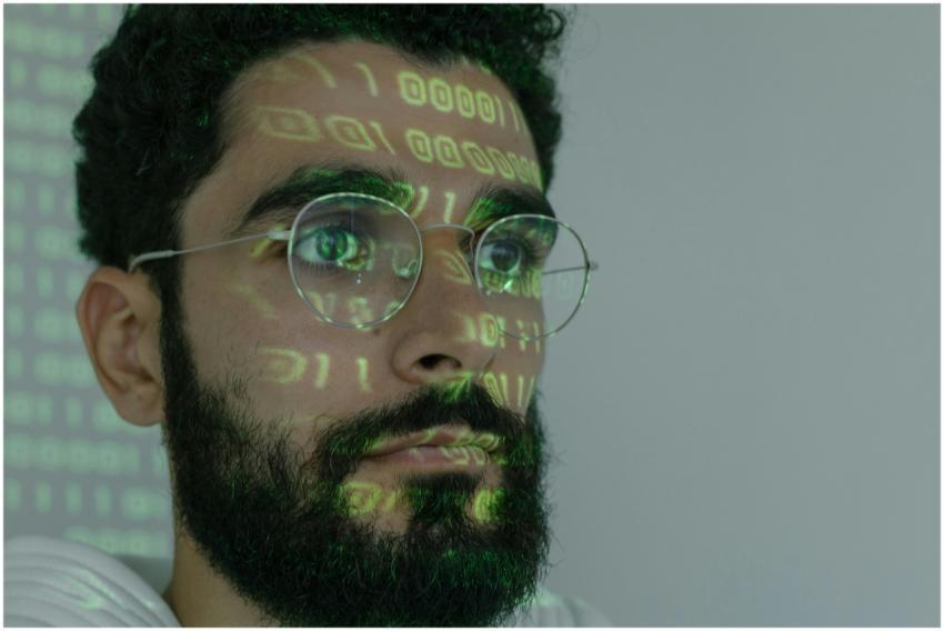 A bearded man with digital binary code projected o