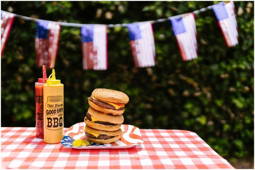 Stacked burgers on a table with American flag deco